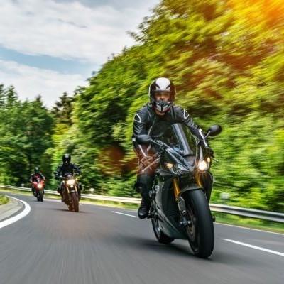 Road with 3 motorcyclists riding towards the camera