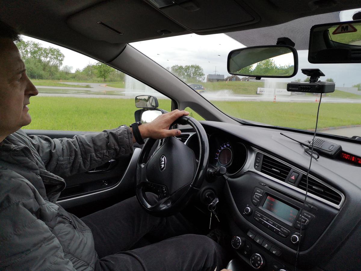 Trainee-driver drives alone in an non-public training ground with buil-in street network.